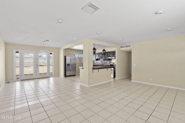 unfurnished living room with light tile patterned floors and french doors