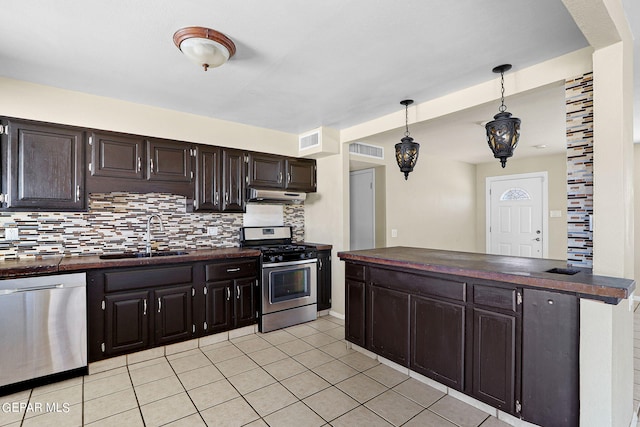 kitchen featuring sink, hanging light fixtures, decorative backsplash, light tile patterned flooring, and stainless steel appliances