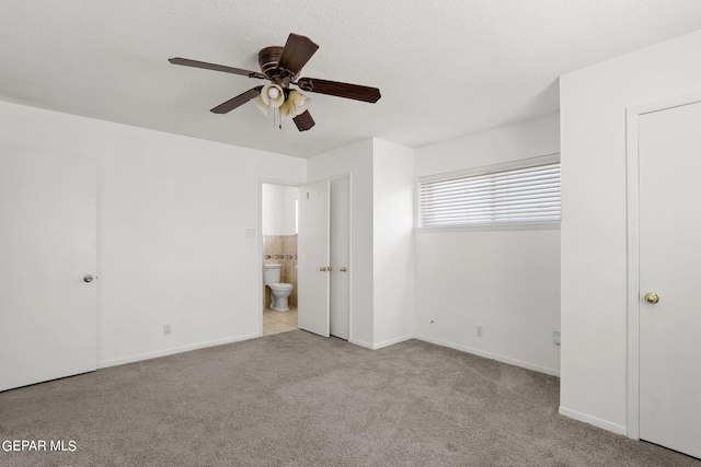 unfurnished bedroom featuring connected bathroom, light colored carpet, and ceiling fan