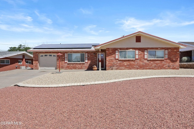 single story home featuring solar panels and a garage