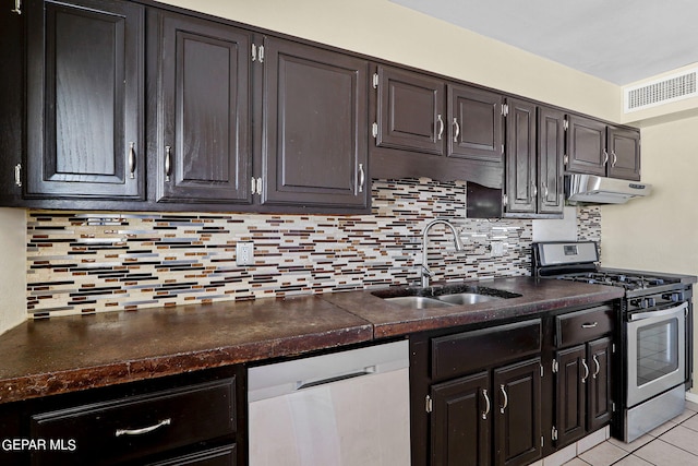 kitchen with gas range, dishwasher, sink, backsplash, and light tile patterned floors