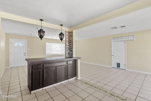 kitchen with pendant lighting, light tile patterned floors, and dark brown cabinets