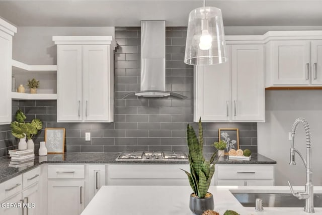 kitchen with decorative backsplash, white cabinets, and wall chimney exhaust hood