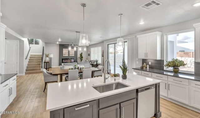 kitchen with plenty of natural light, an island with sink, sink, and stainless steel dishwasher