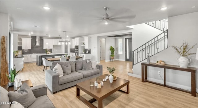 living room with light hardwood / wood-style flooring and ceiling fan