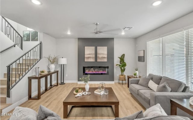 living room with ceiling fan and light hardwood / wood-style flooring