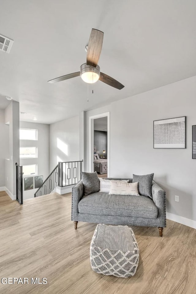 living area featuring light wood-type flooring and ceiling fan