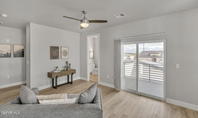 living room with ceiling fan and light hardwood / wood-style flooring