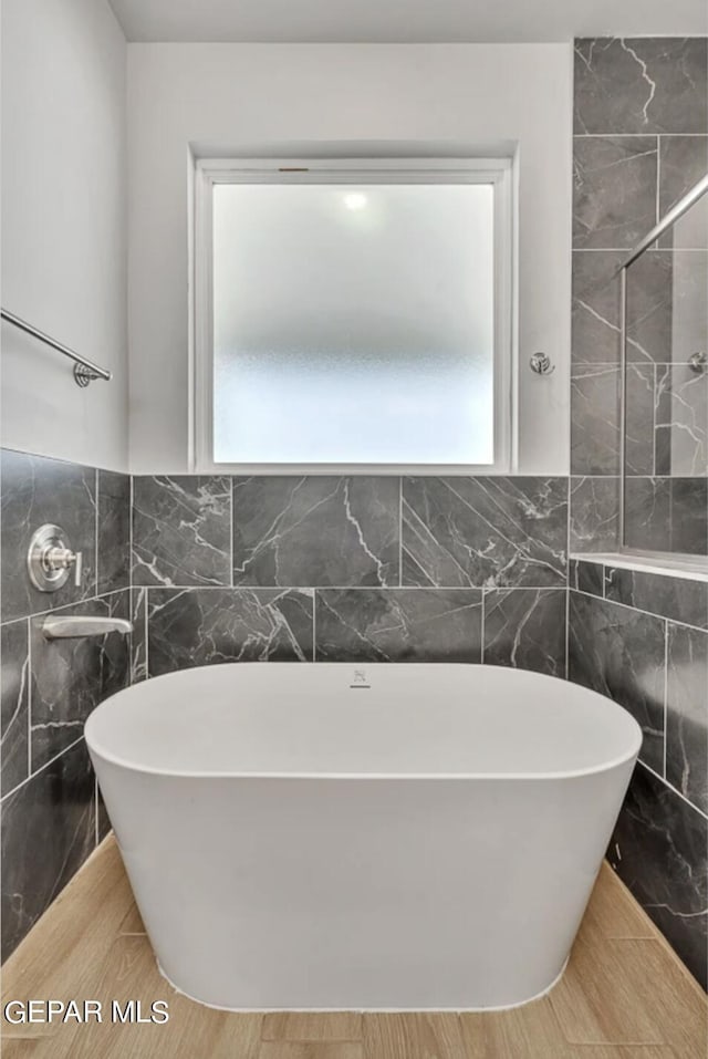 bathroom featuring tile walls and a wealth of natural light