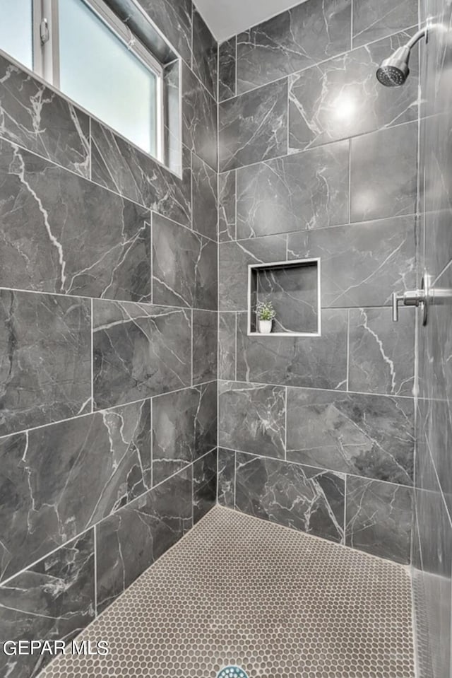 bathroom featuring a tile shower