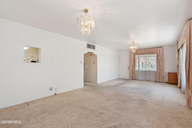 unfurnished living room with carpet flooring and a notable chandelier