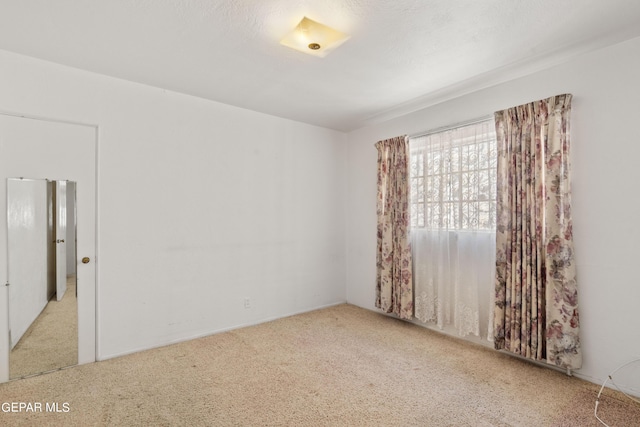 carpeted spare room featuring a textured ceiling