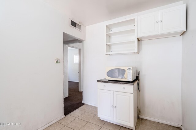 kitchen featuring white cabinets and light tile patterned floors