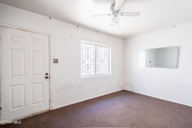 carpeted spare room with ceiling fan and baseboards