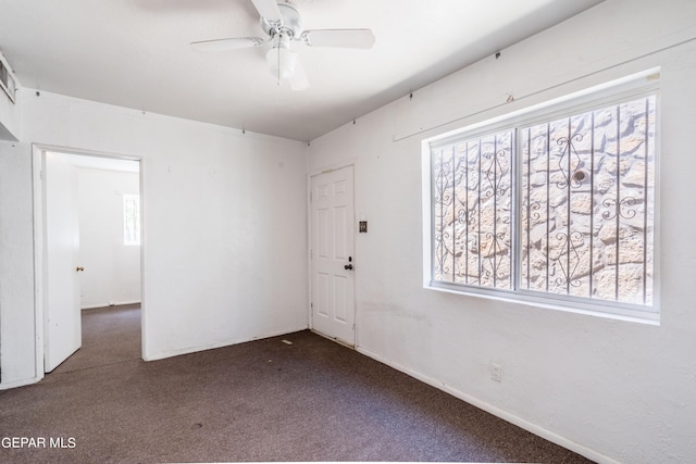 carpeted spare room featuring a ceiling fan