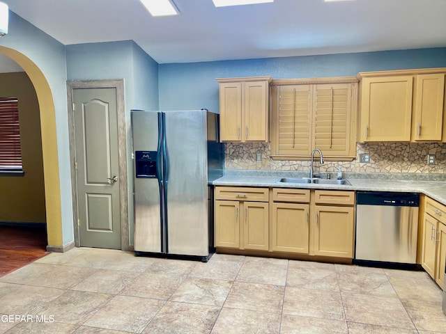 kitchen featuring sink, tasteful backsplash, a wall mounted AC, stainless steel appliances, and light brown cabinetry