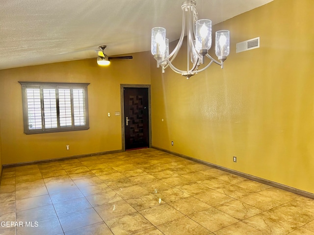 empty room featuring ceiling fan with notable chandelier, lofted ceiling, and a textured ceiling