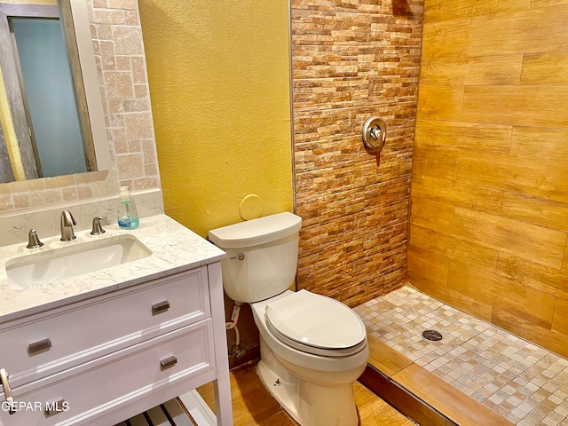 bathroom with walk in shower, vanity, and toilet