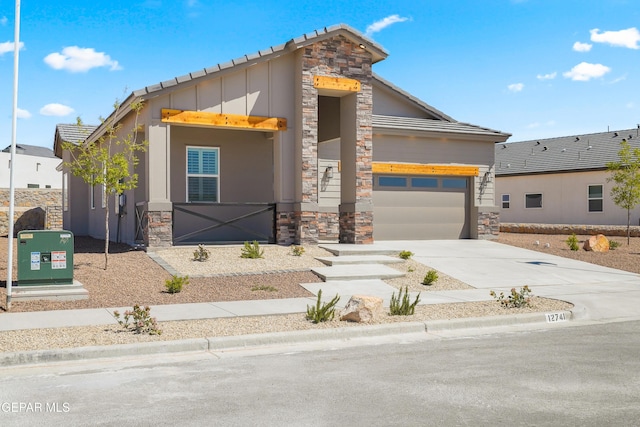 12741 Eltham Dr, Horizon City, TX 79928 - view of front of home with an attached garage, stone siding, board and batten siding, stucco siding, and driveway