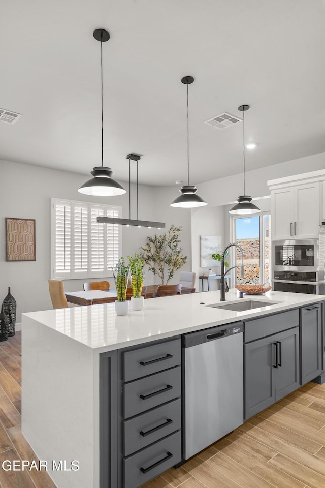 12741 Eltham Dr, Horizon City, TX 79928 - kitchen with a sink, appliances with stainless steel finishes, gray cabinetry, and visible vents