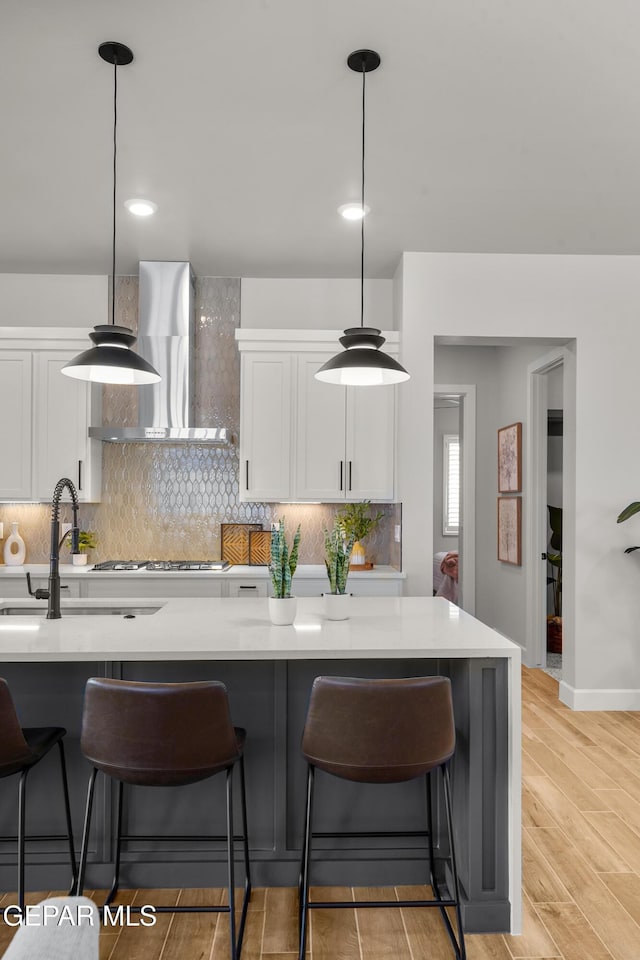 12741 Eltham Dr, Horizon City, TX 79928 - kitchen with wall chimney range hood, a kitchen bar, a sink, and tasteful backsplash