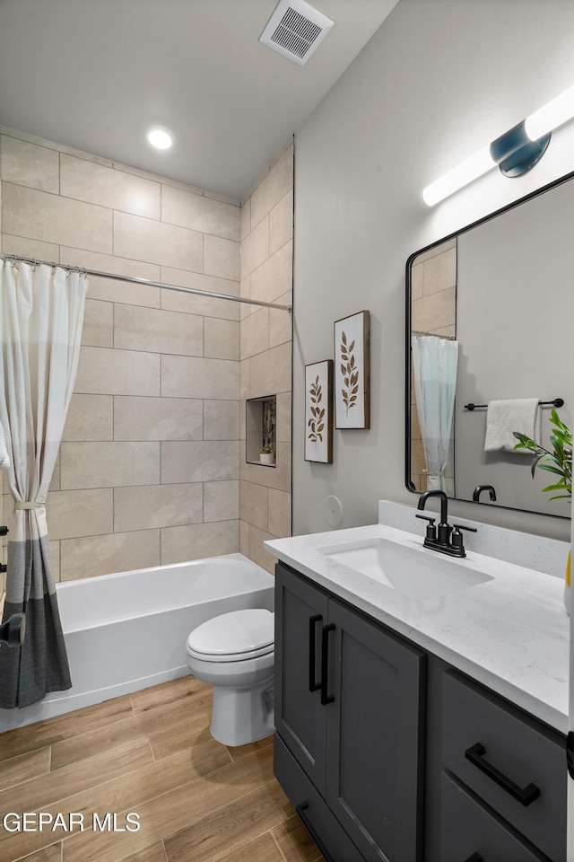 12741 Eltham Dr, Horizon City, TX 79928 - full bath featuring visible vents, vanity, wood finished floors, toilet, and shower / tub combo