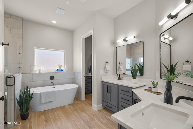 12741 Eltham Dr, Horizon City, TX 79928 - bathroom featuring vanity, wood finished floors, recessed lighting, a soaking tub, and a shower stall