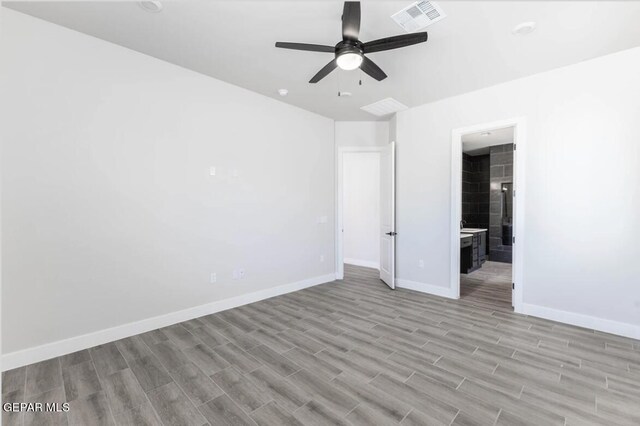 unfurnished bedroom with light hardwood / wood-style flooring, connected bathroom, and ceiling fan