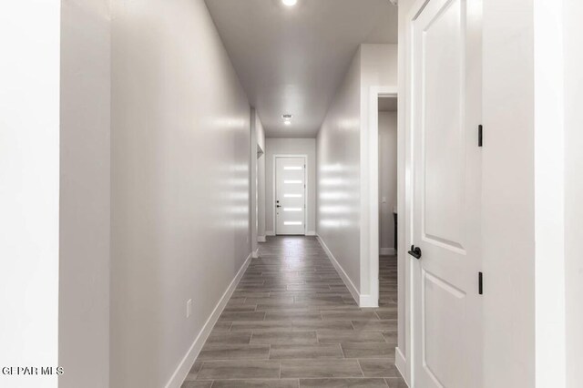 corridor with hardwood / wood-style flooring