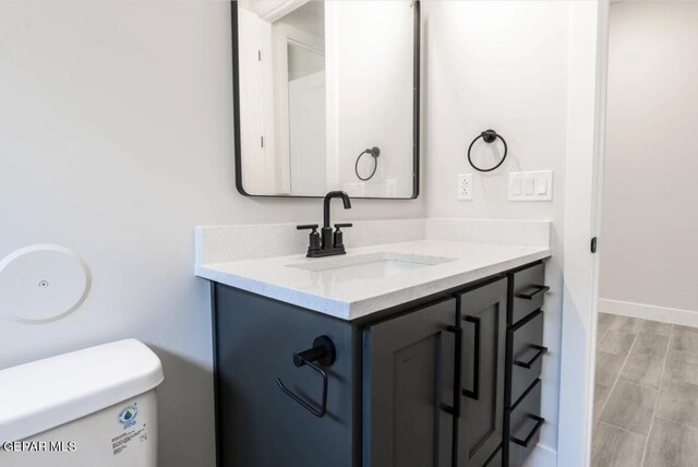 bathroom featuring hardwood / wood-style floors, toilet, and vanity