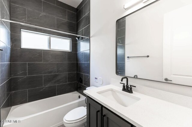 full bathroom with vanity, tiled shower / bath combo, and toilet