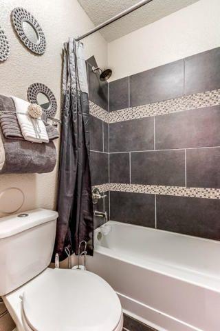 bathroom featuring shower / tub combo with curtain, a textured ceiling, and toilet