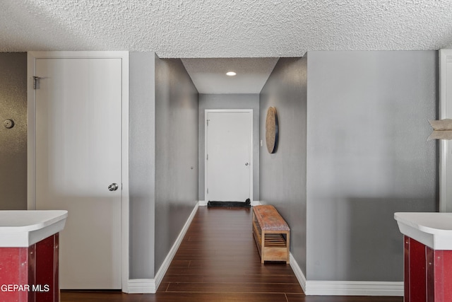 hallway featuring dark wood-type flooring and a textured ceiling