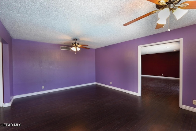 empty room with ceiling fan, dark hardwood / wood-style floors, and a textured ceiling