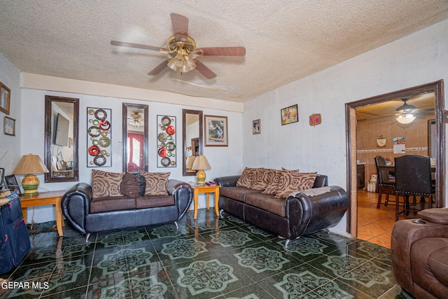 living room with a ceiling fan, a textured ceiling, and tile patterned floors