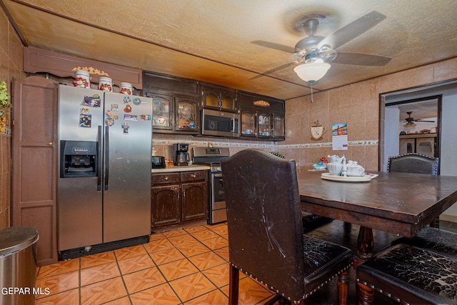 dining room with light tile patterned floors, tile walls, and a textured ceiling