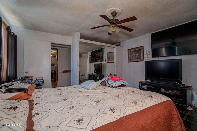 bedroom featuring a textured ceiling, ceiling fan, and a closet