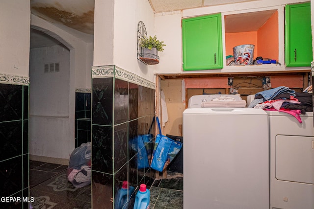 laundry room with tile walls, visible vents, washing machine and dryer, wainscoting, and laundry area