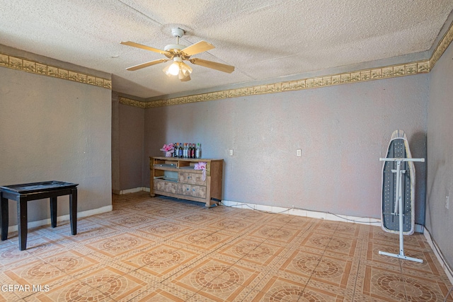 empty room featuring a ceiling fan, a textured ceiling, and baseboards