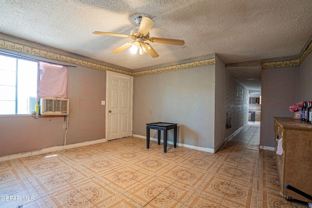 unfurnished room with a ceiling fan, a textured ceiling, baseboards, and cooling unit