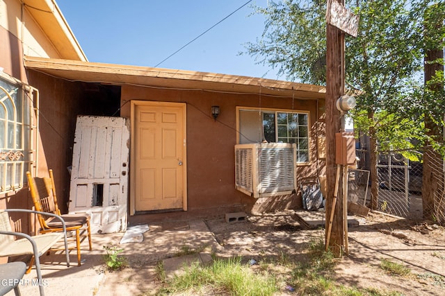 property entrance with fence and stucco siding