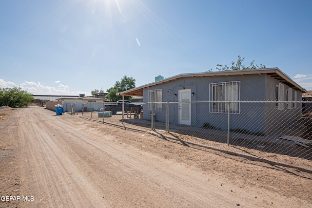 view of front facade featuring driveway, fence, and stucco siding