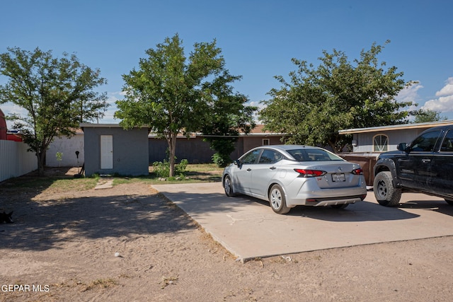 view of front of home with an outbuilding, fence, and a storage shed