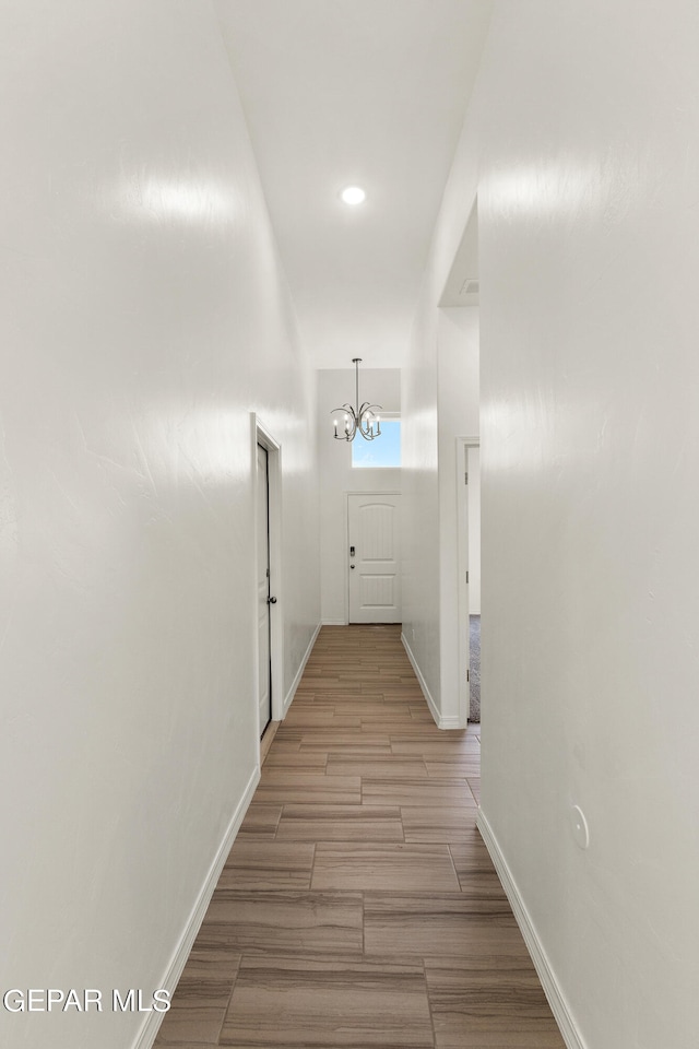 hallway featuring a notable chandelier