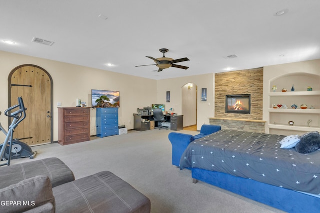 bedroom featuring a fireplace, carpet floors, and ceiling fan