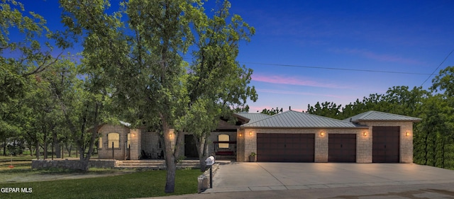 view of front of property featuring a standing seam roof, metal roof, an attached garage, and concrete driveway
