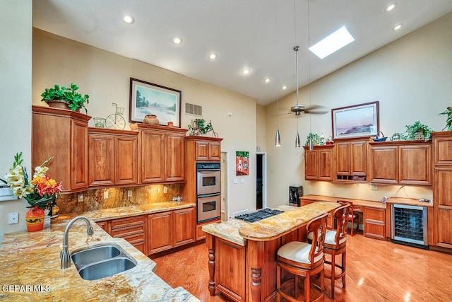 kitchen with sink, wine cooler, tasteful backsplash, a kitchen bar, and kitchen peninsula