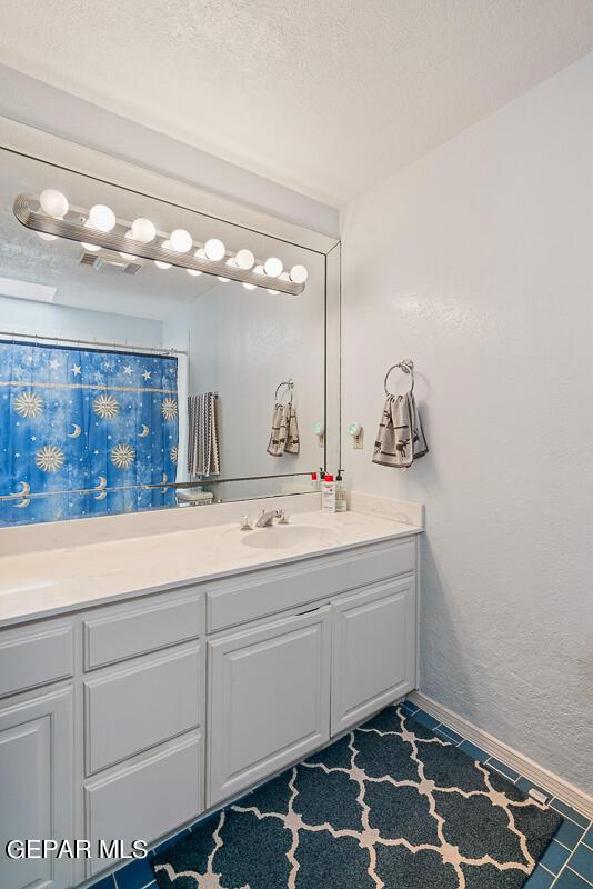 bathroom with vanity and a textured ceiling