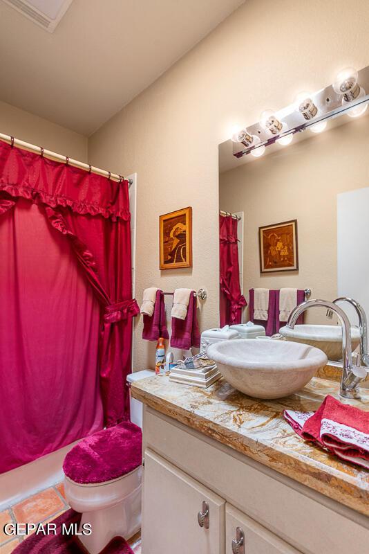 bathroom with tile patterned flooring, vanity, and toilet