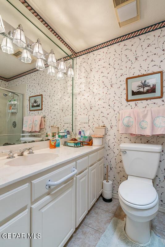 bathroom featuring vanity, an enclosed shower, tile patterned floors, and toilet